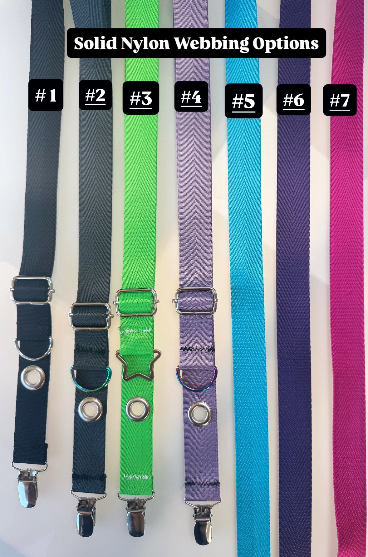Seven solid nylon webbing straps in different colors, numbered #1 through #7, displayed vertically with silver metal clips and adjusters. A black label at the top reads 'Solid Nylon Webbing Options'.