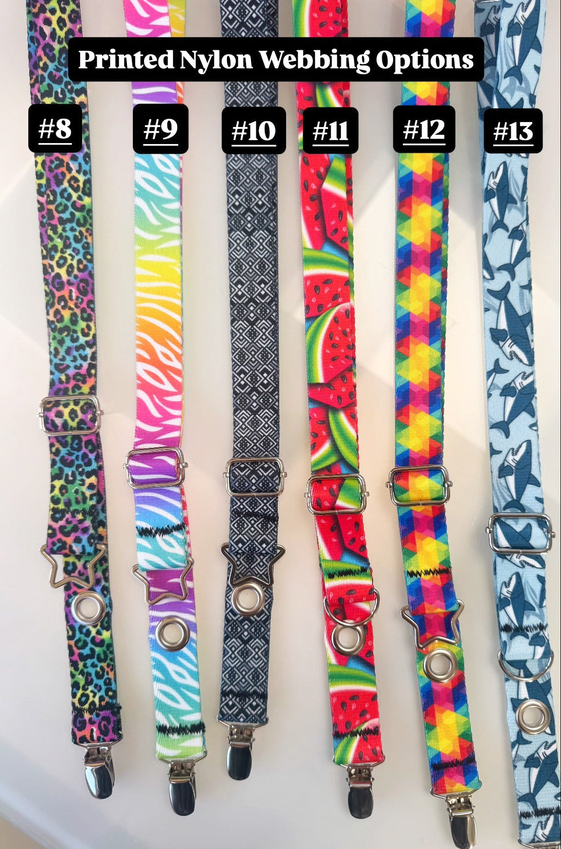 Six printed nylon webbing straps with metal clips are displayed side by side on a light background, labeled #8 through #13. The webbings feature various colorful patterns including leopard print, zebra print, black-and-white geometric, watermelon fruit, rainbow stripes, and shark designs.