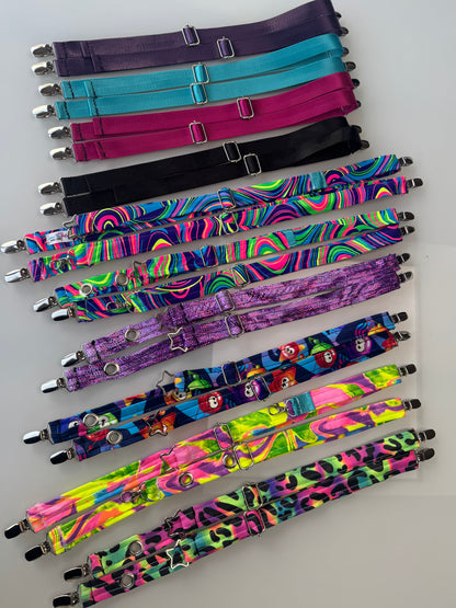 The Universal Magic Straps shown flat-laid in tons of different colors with silver attachment point hardware.